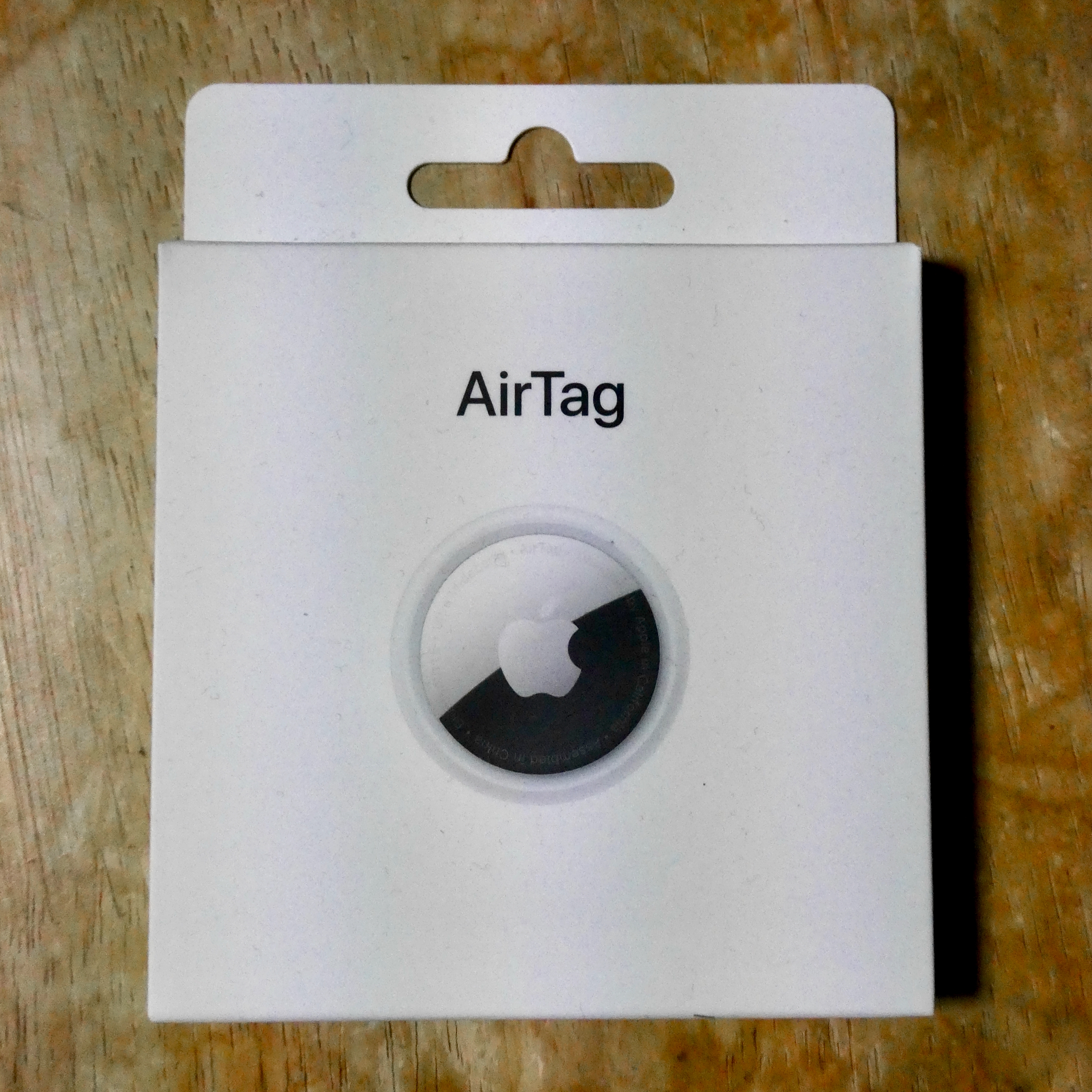 A small circular Bluetooth item tracker placed on a flat surface, illustrating how AirTags and trackers are used