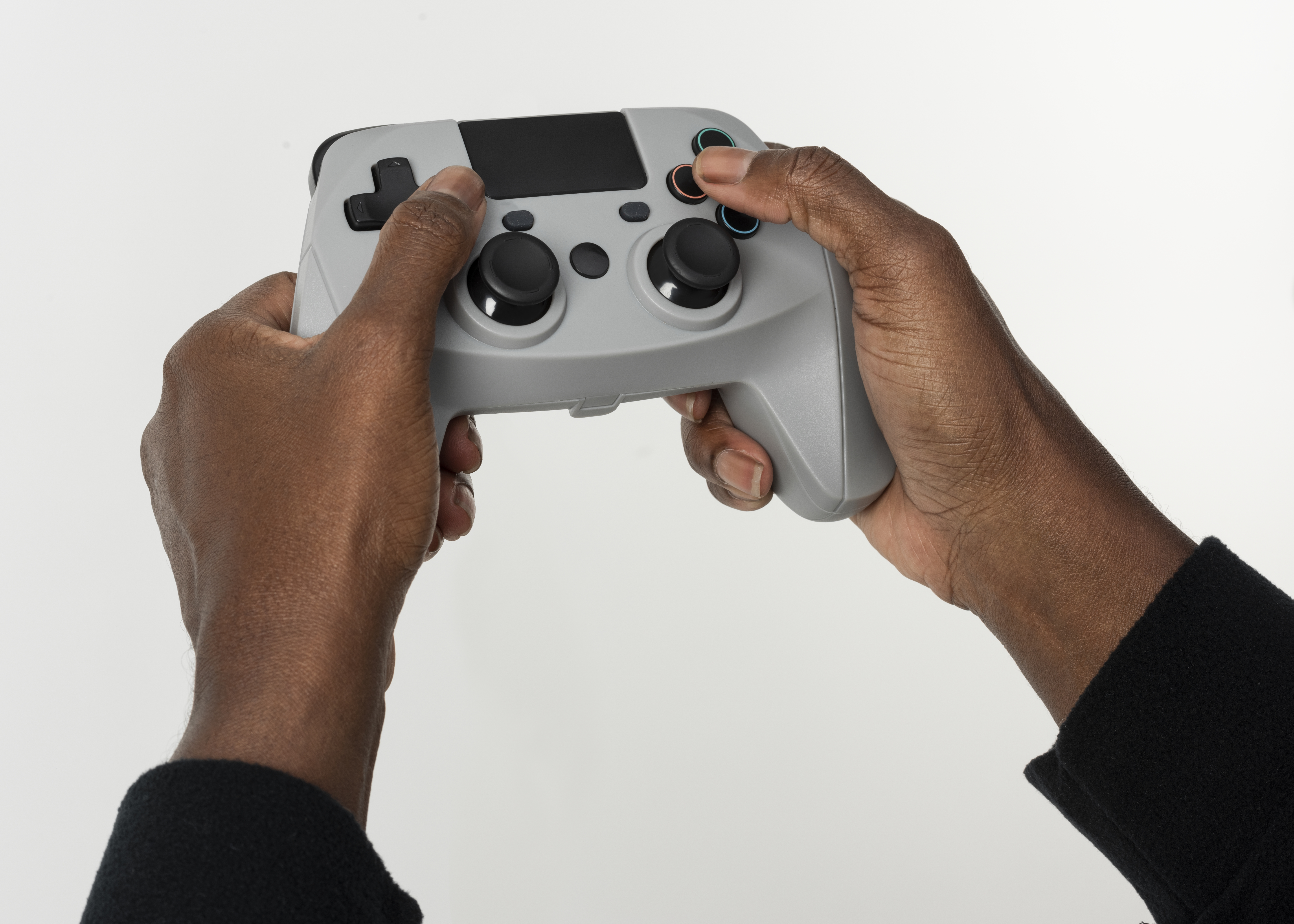 Hands holding a modern game controller, symbolizing the shared-screen co-op moment in family gaming