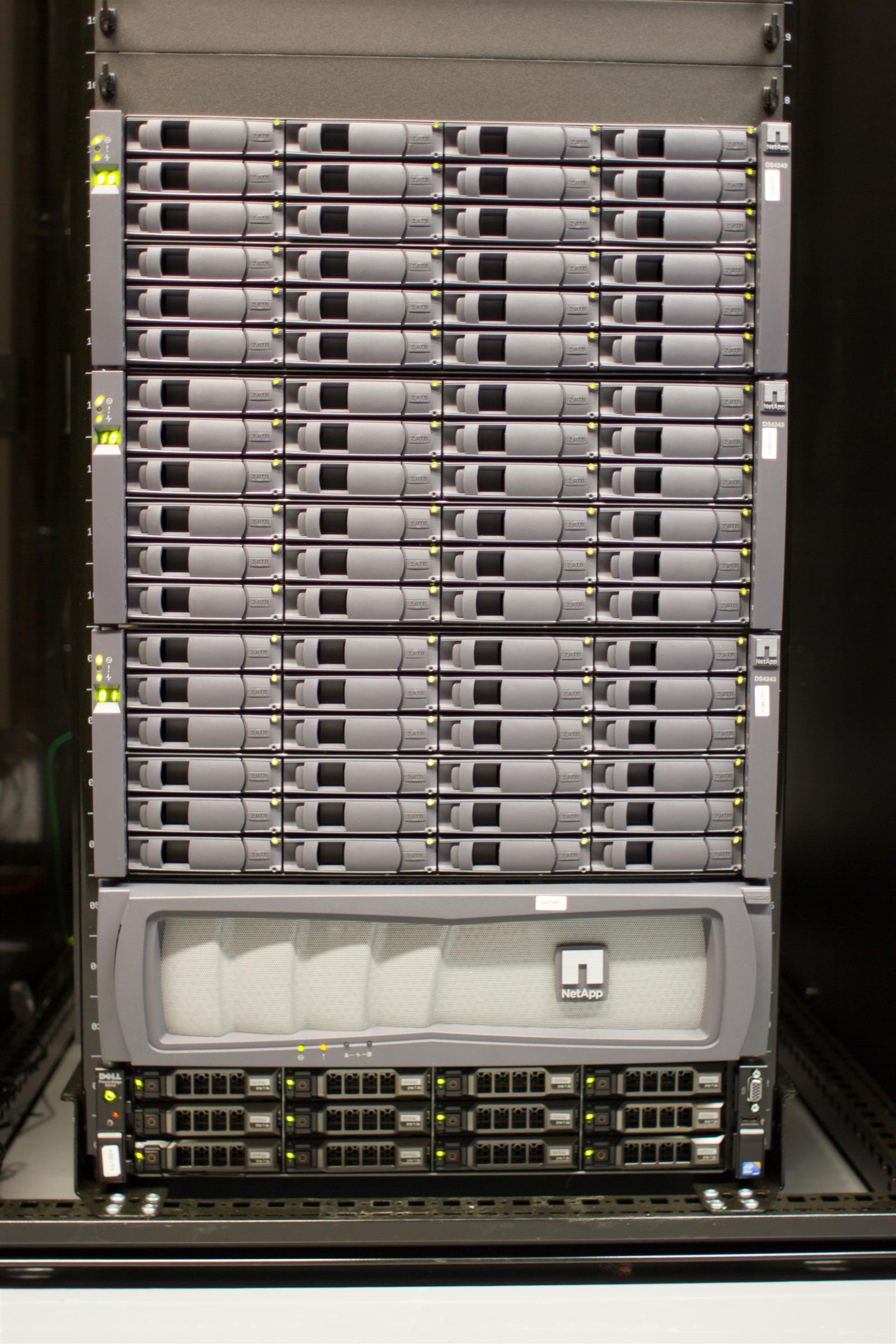 A dense rack of network servers and disk shelves, standing in for the infrastructure behind the npm registry and the fallout from its 2026 breaches